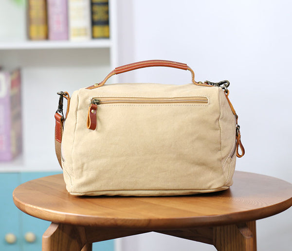 Beige handbag with brown handles and accents on a wooden table